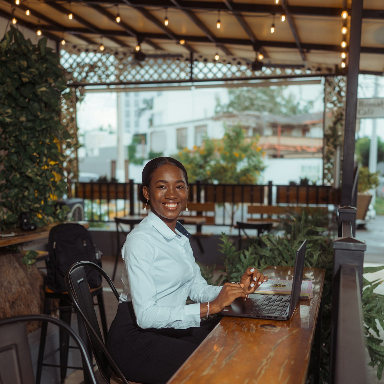 Small business owner smiling while working on a laptop at her shop counter